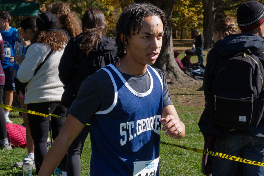 A teenager runs wearing a sports tank top.