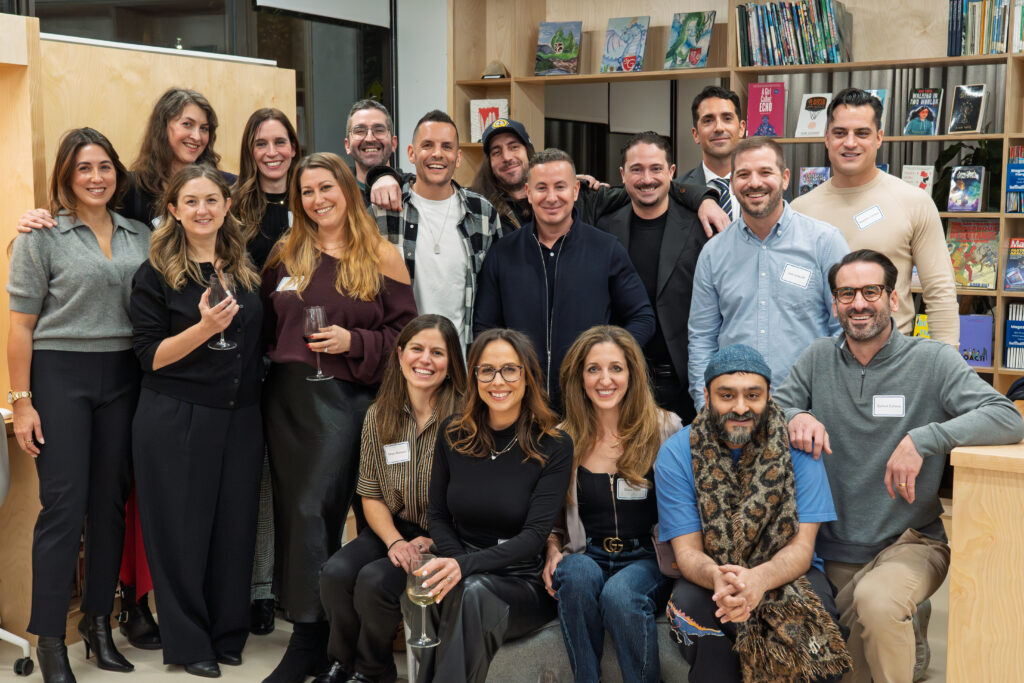 A group of alumni stand together in a library.