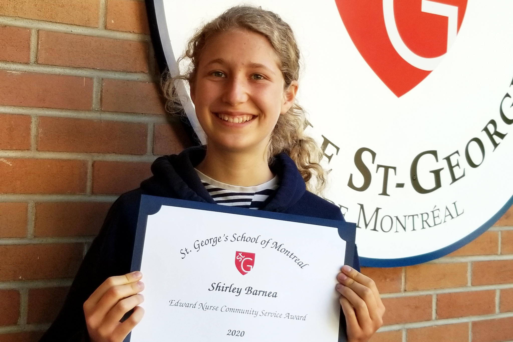 Smiling female student holding a certificate.