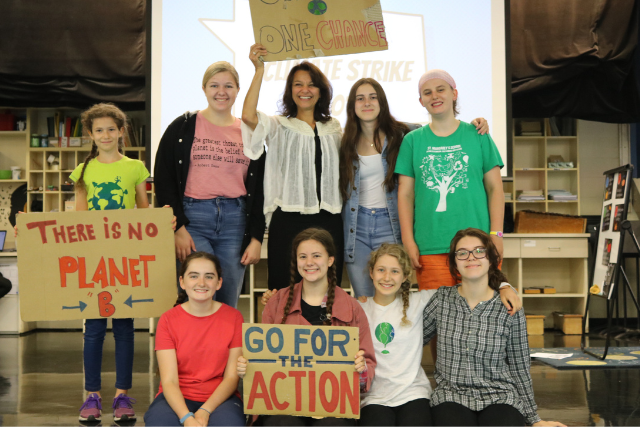 Teenages onstage with climate change posters.