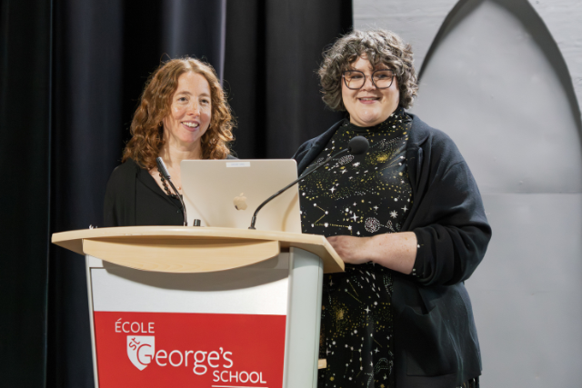 Two women stand at a podium.