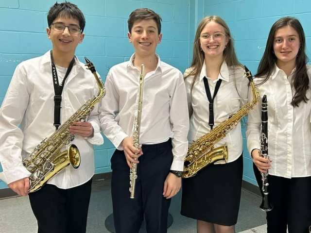 Teenage students hold instruments in a row as part of a band event connected to student life.
