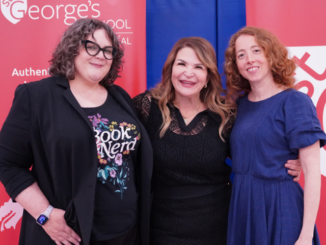 Three smiling women pose together at an indoor event in front of a red step-and-repeat banner reading "St. George's School Montreal.